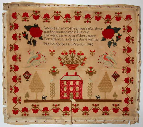 An unframed sampler signed Mary Sykes 1846. Religious text in upper centre above a three storey house surrounded by flowers, with trees, dogs and birds; with a floral border.