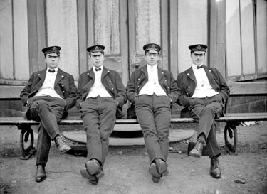 Four sailors sitting on a bench.