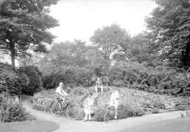 Children on bicycles in Mrs Heaton's garden