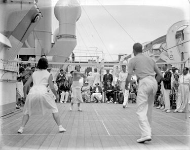Group playing badminton on board ship