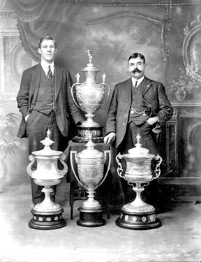 Portrait of two men with trophies