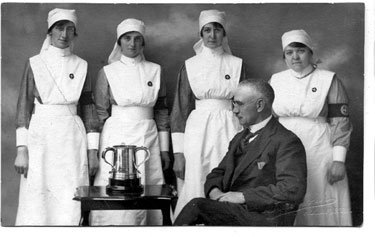 Bamforth Postcard - A Doctor and a group of nurses, with trophy/cup, Holmfirth Auxilliary War Hospital.