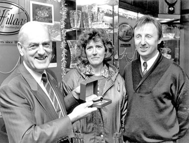 Messrs. Fillans & Sons Ltd, Jewellers, No.2 Market Walk - Nigel Greenwood (right) and wife Jill, have won watch in wordsearch competition run by Examiner - receiving prize from Ian Fillan