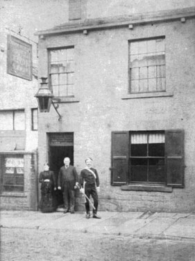 A woman and two men (one of whom is dressed in a military uniform), staning outside a public house