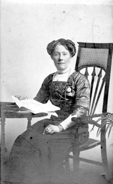 Portrait of a woman seated at a desk.