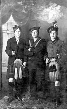 Three ypung women - two dressed in Scottish national dress/uniforms, and one dressed in a sailor's uniform.