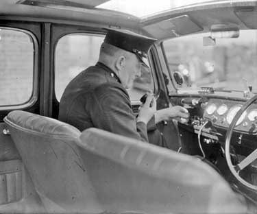 Policeman in car with radio 	
