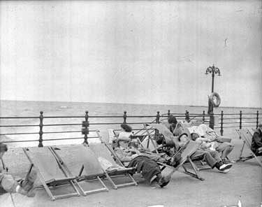 People sitting on Blackpool Promenade 	