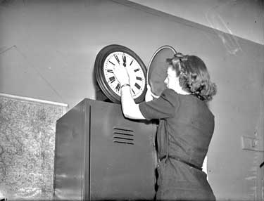 Woman altering clock 	