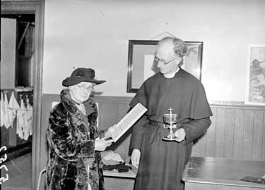 Miss Marshall, aged 80, receiving a scroll from the Reverend F Shaw of Linthwaite 	