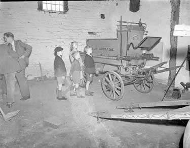 Children inspecting old Fire-engine in Barn 	