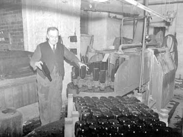 Mr W Gartside checking bottles at Magdale Vinery 	