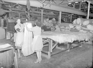 Women working at Rayner Mills, Liversedge. Emma Norris and Joyce Armitage working at Rayner Mills for Versil. The Company made glass blankets for insulating boilers. 	