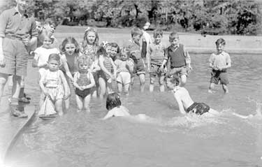 Children playing in the paddling pond in Ravensknowle Park, Dalton, Huddersfield.