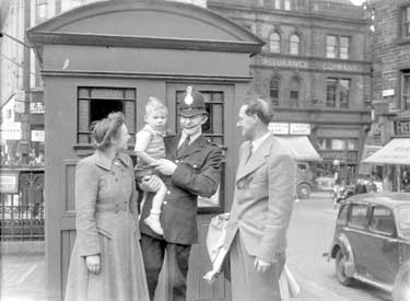 Policeman with child and couple, Market Place, Huddersfield 	