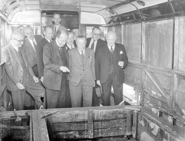 Group of men looking at converted bus 	