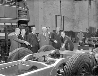 Group of men looking at chassis 	
