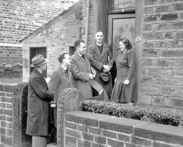 Evangelists talking to woman at door 	