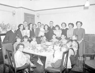 Mrs Gait and her 15 Grandchildren round the tea table 	