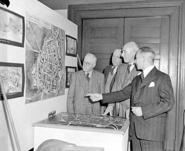 Group of men looking at map 	