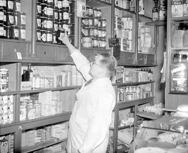 Grocer with jar of jam 	