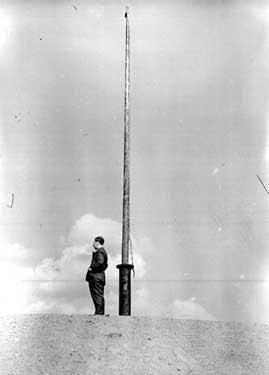 Man standing next to flagpole? 	
