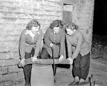 Three women sawing wood 	