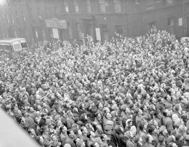 Crowds in Ramsden Street, Huddersfield watching return of Rugby League Team from Challenge Cup Final 	