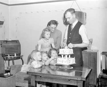 Mr and Mrs G. Hirst and family with coronation cake 	