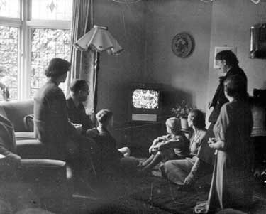Family watching Coronation on the television 	