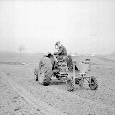 Tractor spreading fertilizer 	