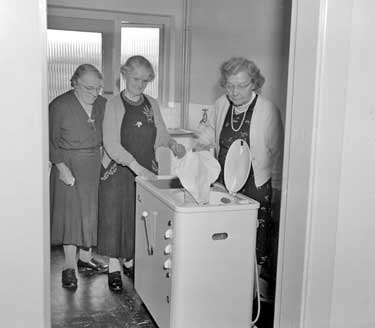 Ladies with washing machine 	