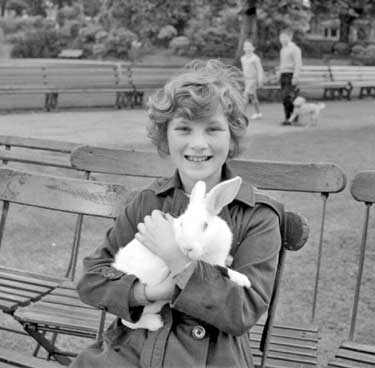 Girl holding White Rabbit in Greenhead Park, Huddersfield. 	