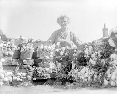 Mrs Hirst of Golcar with sea shells in Garden 	