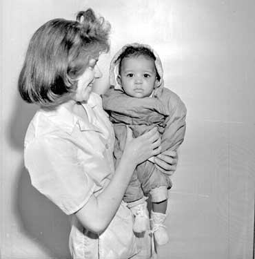 Nurse with baby, left at Kirkgate Flats 	