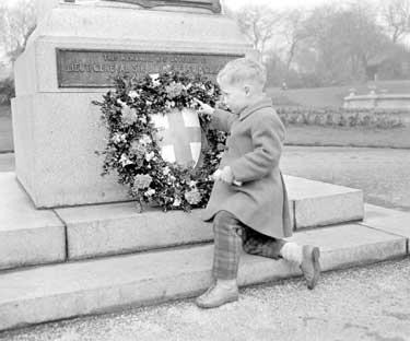 Boy placing wreath at South African War Memorial 	