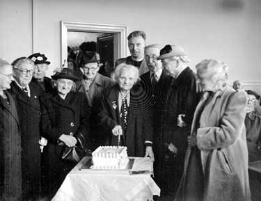 Mrs Shaw Taylor, aged 90, cutting cake at Slaithwaite 	