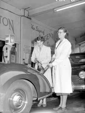 Mother and daughter petrol pump attendants at Newton Garage 	