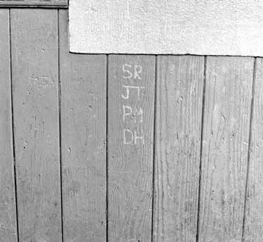 Initials carved in wood panneling 	