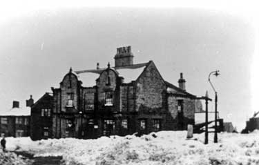 Snow scene in Emley, the Old Cross stands next to a gas oil lamp