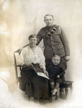Couple with young child, man in first world war uniform.