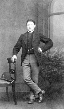 Portrait of a young man leaning on a chair.