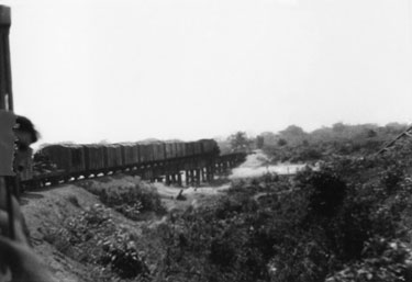 Wartime Archive of Reg Stone of Skelmanthorpe: Taking the Rangoon Railway to Mandalay, via Pegu and Thazi –A new Bailey Bridge constructed by the Royal Engineers, Mandalay, Burma – The old bombed bridge can be seen to the right-hand side of the photograph. 