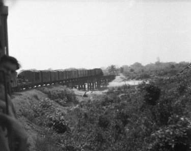 Royal Air Force 1543805 R.O. Stone East Bengal and Burma 1943-1946: Black and White Negatives of various photographs taken over that period – Taking the Rangoon Railway to Mandalay, via Pegu and Thazi – A new Bailey Bridge constructed by the Royal Engineers, Mandalay, Burma – The old bombed bridge can be seen to the right-hand side of the photograph.