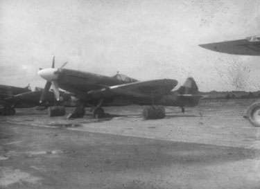 Royal Air Force 1543805 R.O. Stone East Bengal and Burma 1943-1946: Black and White Negatives of various photographs taken over that period – Spitfire Fighter Plane, Mingaladon Airfield, Rangoon, Burma – “Drums of cement were used to anchor certain planes during the typhoon season,” Reg Stone.
