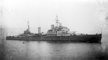 Postcard of the HMS Gambia 'Fiji' Class Cruises, landed 1940, completed 1942. Adopted by the town of Huddersfield during “Warship Week” in 1942. Served with the Royal New Zealand Navy in the Pacific 1944-45, scrapped in 1968.