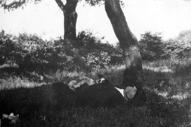 Photo Album Containing Various Images: "A Siesta" - a man lying down under a tree with Dippo, the Jack Russell Terrier.