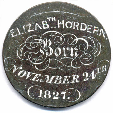 A bronze George III third-issue halfpenny coin which has been polished on one side in order to produce a memento; on one side is the name Elizabeth Hordern, with the date 24th November 1827 (which was a Saturday) - the letters are of a relatively high standard, and the design has been emphasised by the application of a white substance; the other side has been left in its original, though very worn, state.