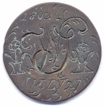 A bronze halfpenny coin which has been polished on both sides in order to produce a love token; on one side is engraved the cypher WS within the date 27th July 1802 (which was a Tuesday); on the other side is . . . . .; the quality of engraving of the central monogram/cypher appears to be of a much higher standard than the surrounding date, and - especially - two vases of flowers.