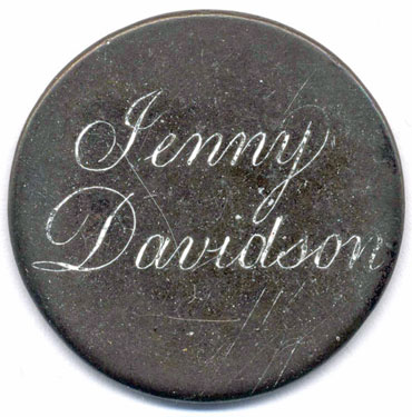 A bronze George II halfpenny coin which has been polished on both sides in order to produce a love token; the reverse simply shows the name Jenny Davidson - the engraving is of a good standard, and the letters have been emphasised by the application of a white substance; the obverse has been polished and left blank, but the vague outline of George II remains.